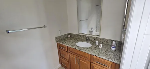 a bathroom with a granite countertop sink and a mirror