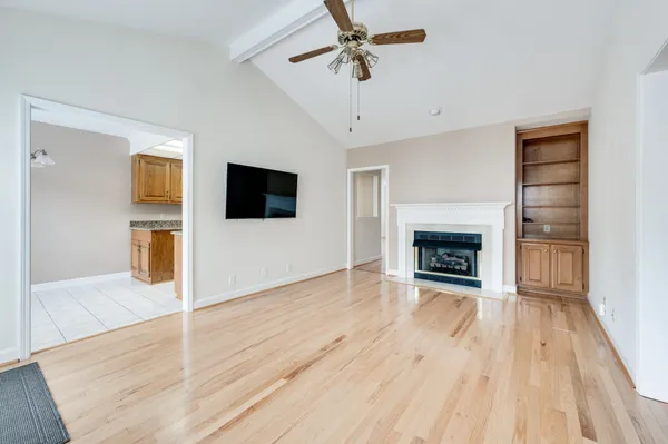 a view of a livingroom with wooden floor and a fireplace