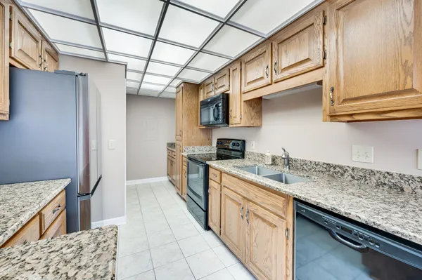 a kitchen with stainless steel appliances granite countertop a sink a stove and cabinets