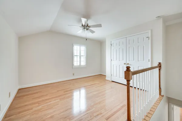 a view of a livingroom with wooden floor and a ceiling fan
