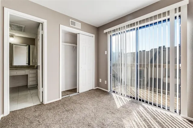 a view of a room with a large window and wooden floor
