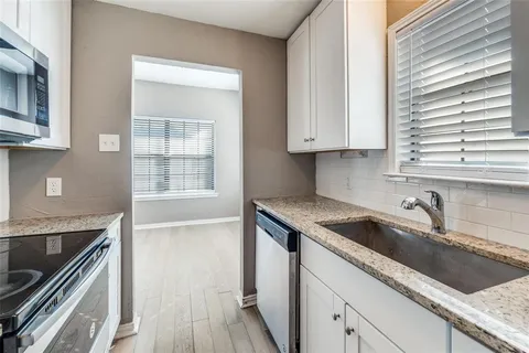 a kitchen with granite countertop a sink and a stove