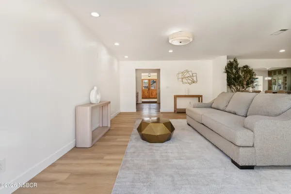 a living room with furniture and a wooden floor