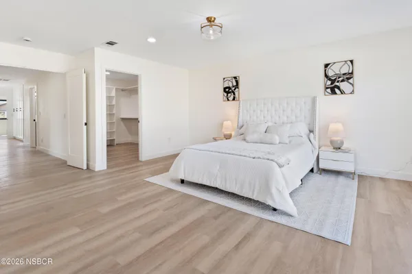 a spacious bedroom with a bed and a walk in closet