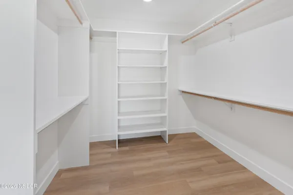 a view of walk in closet with empty racks
