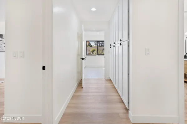 a view of a hallway with wooden floor and staircase