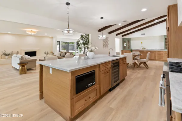 a open kitchen with stainless steel appliances granite countertop a stove oven and a fireplace with wooden floor