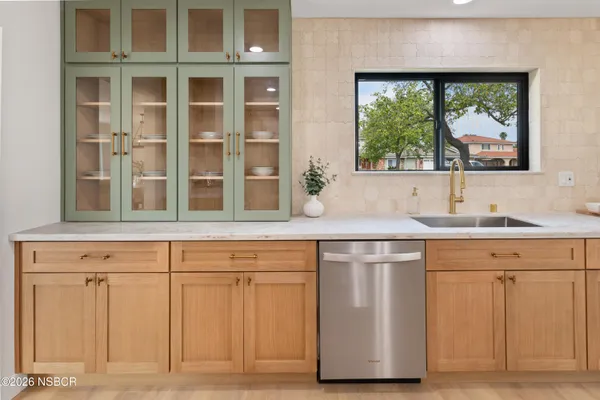 a sink with a window and cabinets