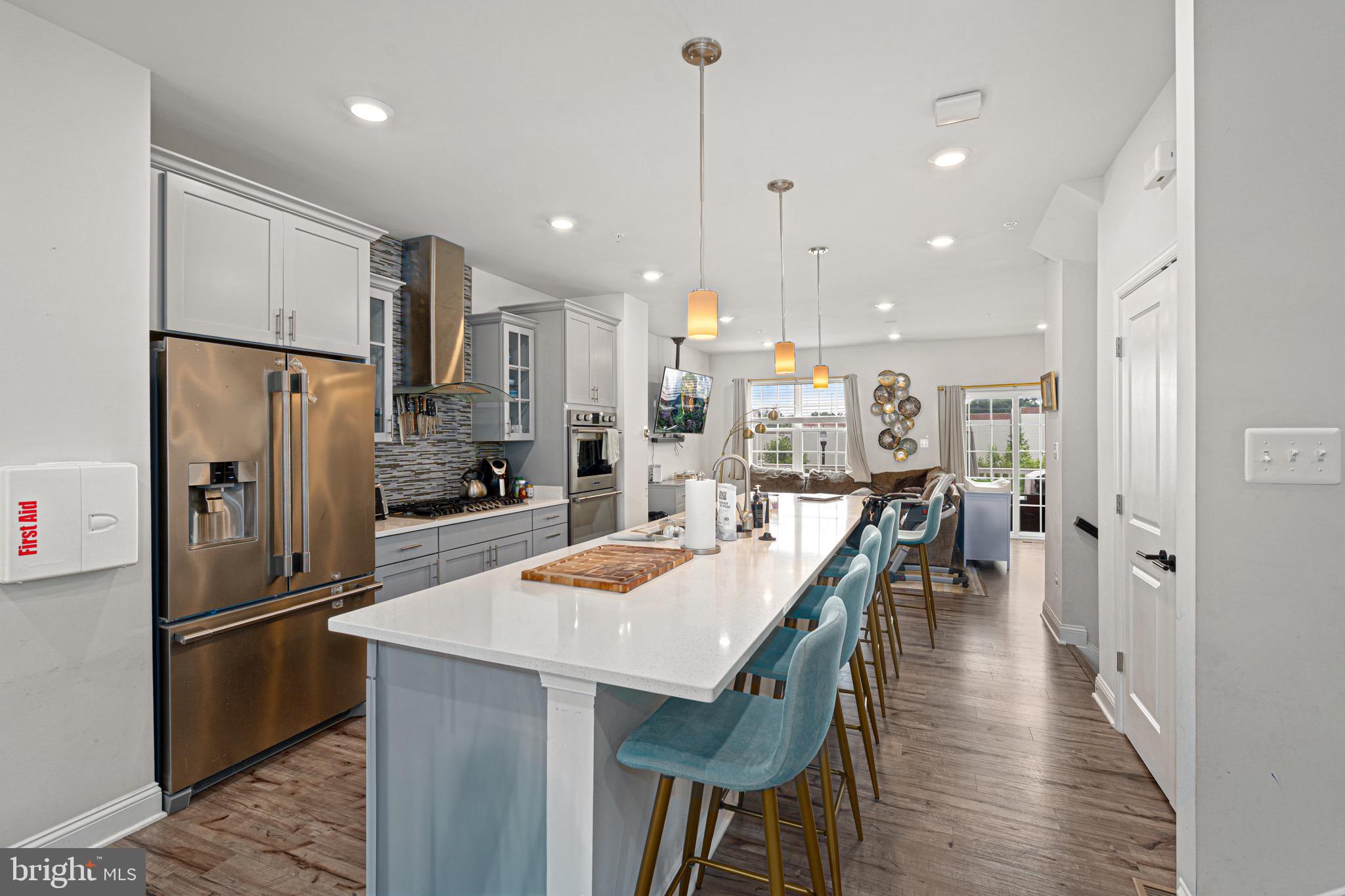 7583 Marston Way Hanover, MD 21076 - Photo 6 of 36 a kitchen with stainless steel appliances kitchen island granite countertop a refrigerator a sink a stove and a refrigerator with wooden floor
