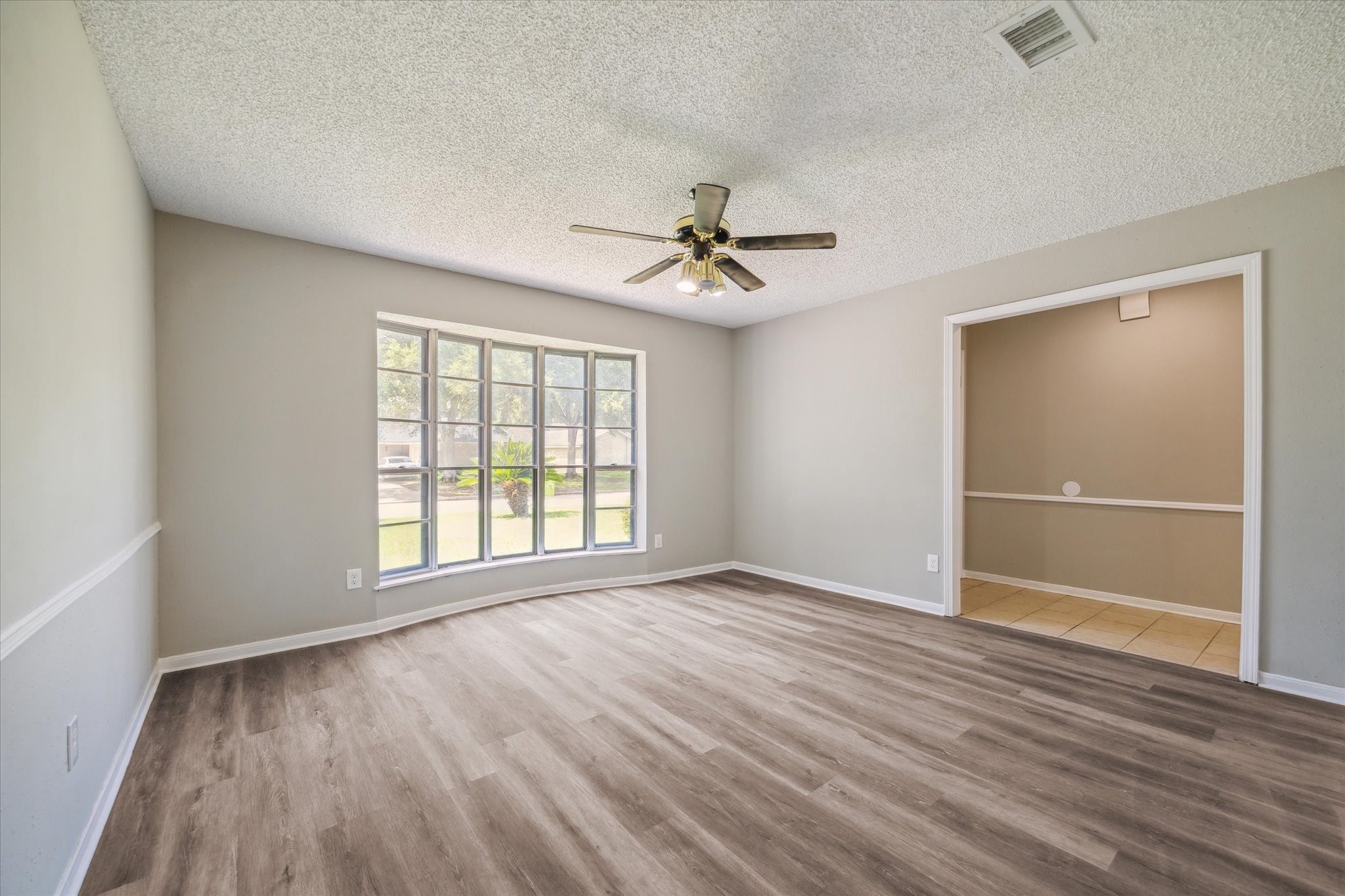 2717 Parrott Avenue Rosenberg, TX 77471 - Photo 9 of 20 a view of an empty room with a window and wooden floor