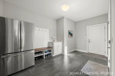 a view of a kitchen with refrigerator and wooden floor