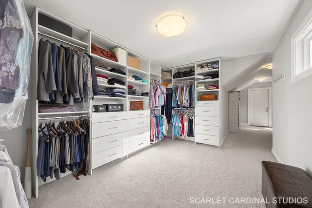 a view of walk in closet with clothes and shoes