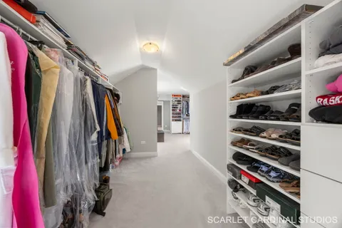 a view of walk in closet with clothes and shoes