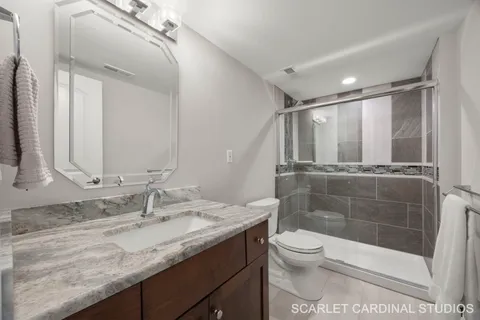 a bathroom with a granite countertop sink toilet and shower