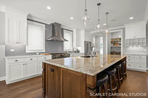 a kitchen with stainless steel appliances granite countertop a sink a stove and a wooden floors