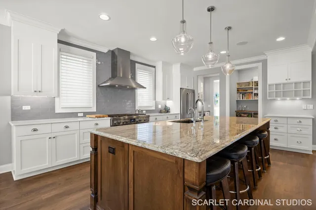 a kitchen with stainless steel appliances granite countertop a sink a stove and a wooden floors