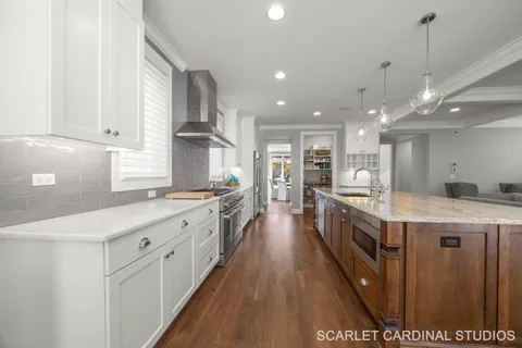 a large kitchen with stainless steel appliances granite countertop a large counter top a stove and a refrigerator