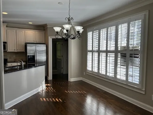 a view of a dining room with furniture a chandelier and wooden floor