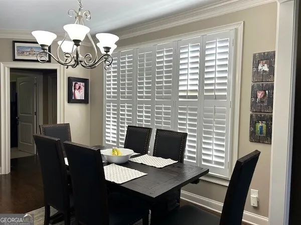 a kitchen with a dining table chairs stainless steel appliances and cabinets