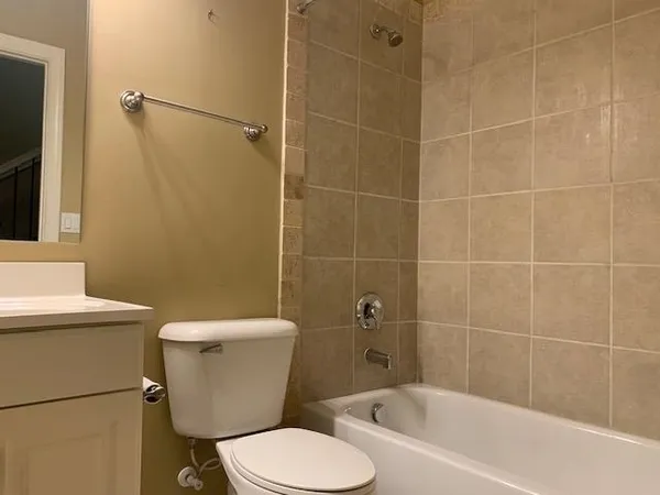 a white toilet sitting next to a bath tub