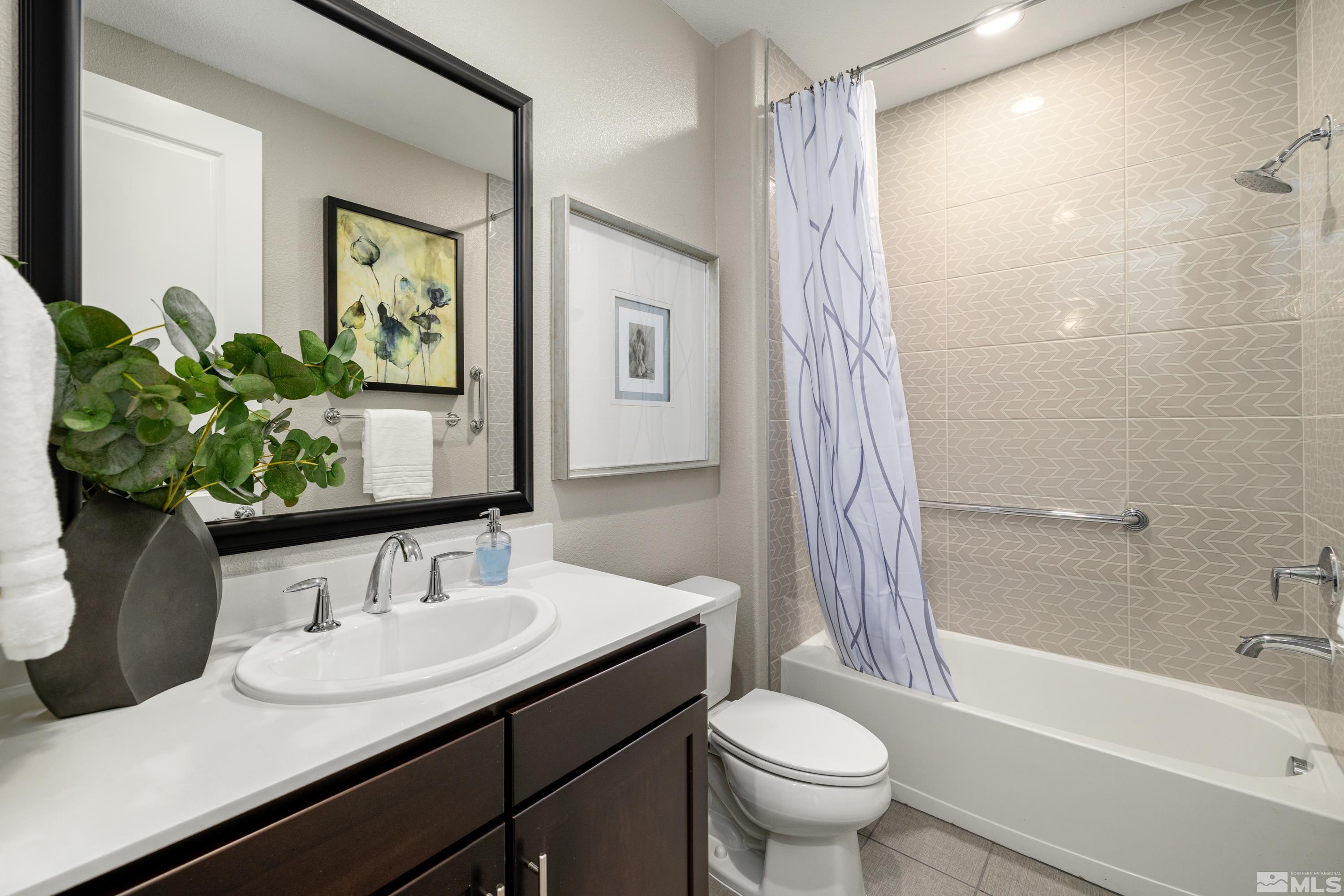 9940 Bernborough Drive Reno, NV 89521 - Photo 19 of 40 a bathroom with a granite countertop sink a toilet a mirror and shower