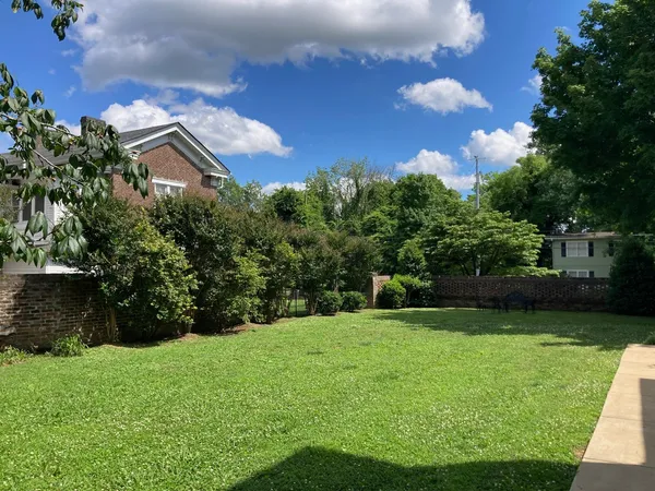 a living room with furniture a rug and a floor to ceiling window