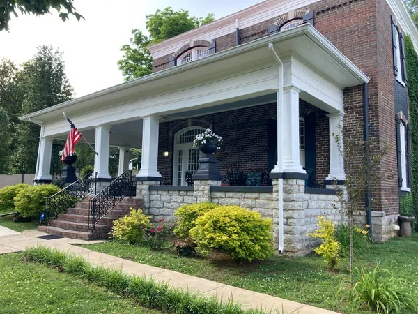 a view of a house with potted plants and a fountain