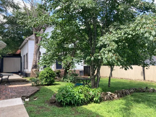a view of a backyard with table and chairs under an umbrella