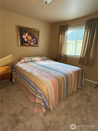 a bedroom with a bed and painting on the wall