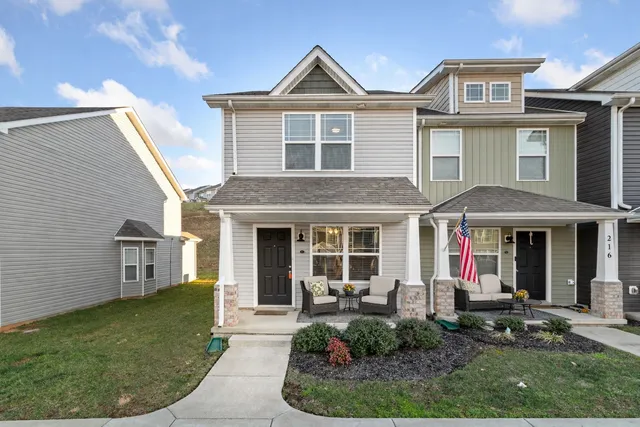 a view of a white house with large windows and a yard