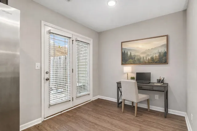 a view of a workspace with furniture and a window