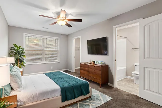 a bedroom with a bed television and a window