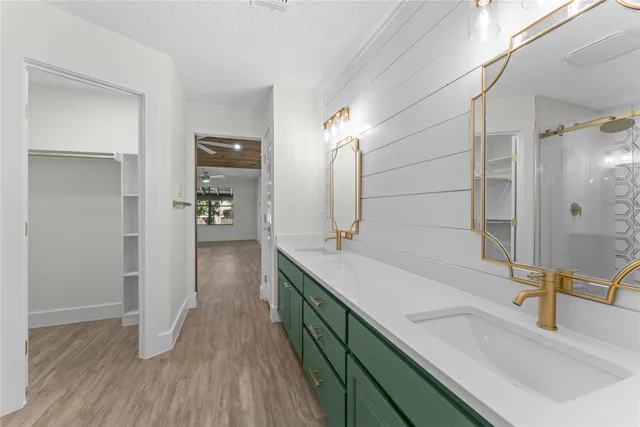 a bathroom with a double vanity sink a mirror and shower