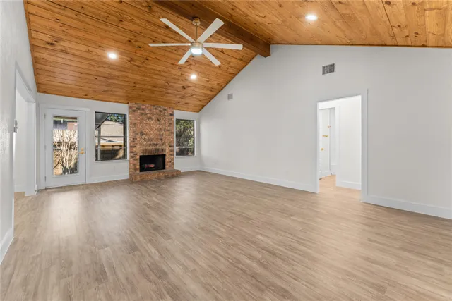 an empty room with wooden floor and fireplace