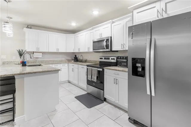 a kitchen with stainless steel appliances granite countertop a refrigerator sink and stove
