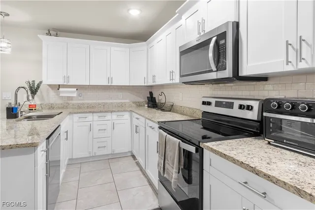 a kitchen with stainless steel appliances granite countertop a sink stove and microwave