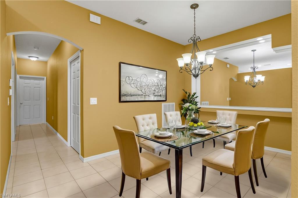 7820 Sandpine Court, Unit 2304 Naples, FL 34104 - Photo 13 of 50 a dining room with furniture and chandelier