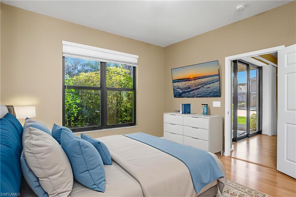 7820 Sandpine Court, Unit 2304 Naples, FL 34104 - Photo 16 of 50 a bedroom with a bed and a large window