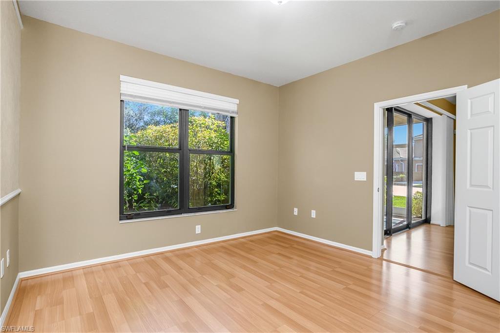 7820 Sandpine Court, Unit 2304 Naples, FL 34104 - Photo 17 of 50 a view of an empty room with wooden floor and a window