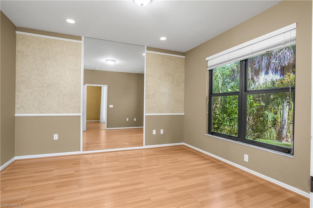 7820 Sandpine Court, Unit 2304 Naples, FL 34104 - Photo 18 of 50 a view of an empty room with a window and wooden floor