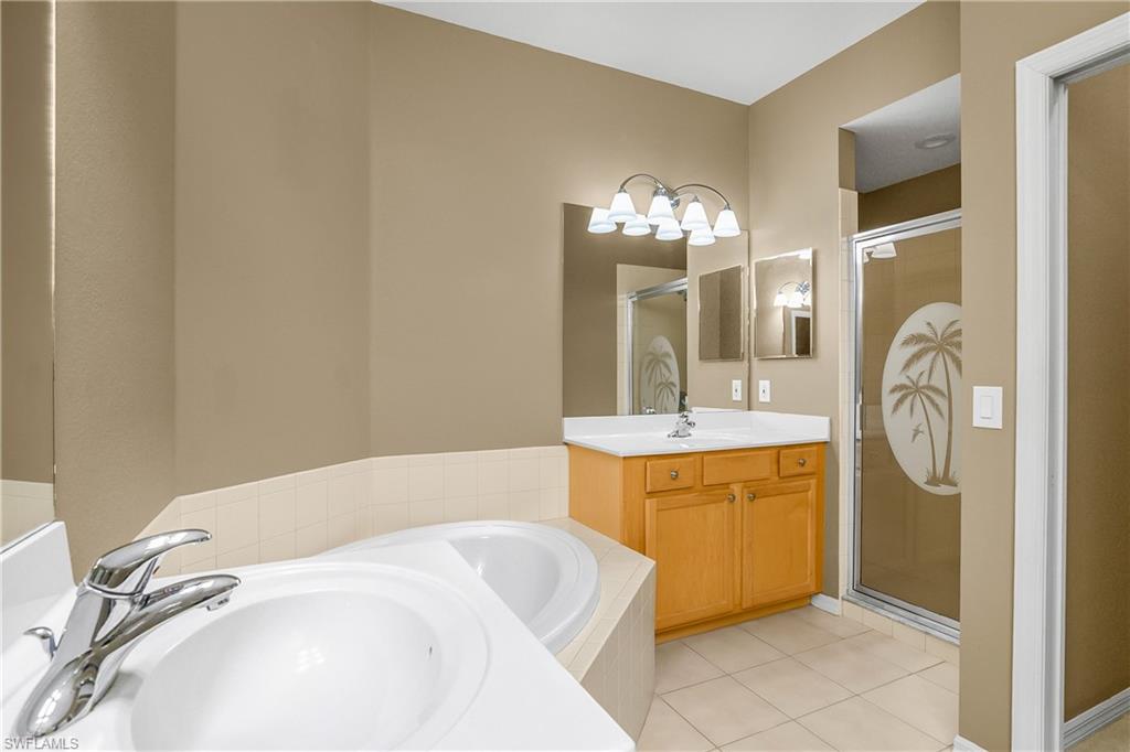 7820 Sandpine Court, Unit 2304 Naples, FL 34104 - Photo 20 of 50 a spacious bathroom with a tub sink and mirror