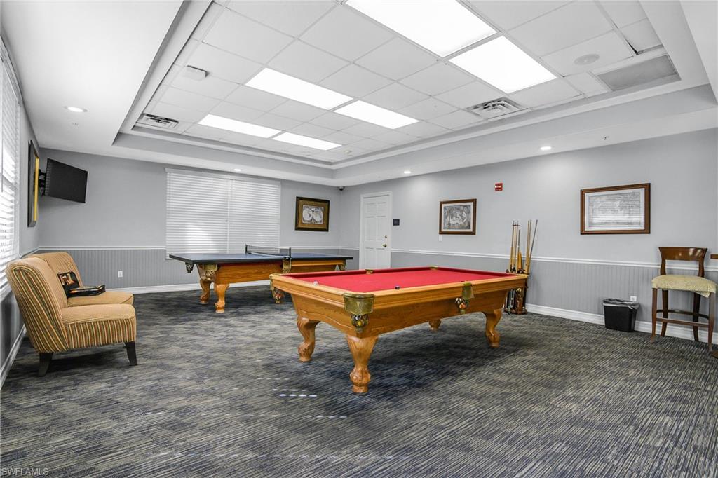 7820 Sandpine Court, Unit 2304 Naples, FL 34104 - Photo 45 of 50 a living room with furniture pool table and a flat screen tv