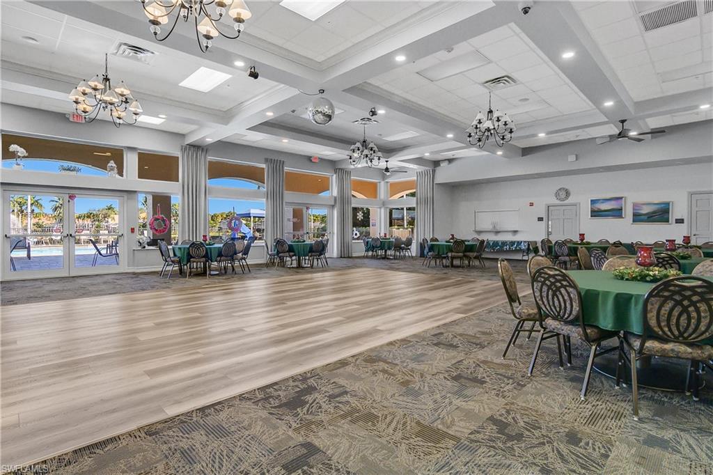 7820 Sandpine Court, Unit 2304 Naples, FL 34104 - Photo 49 of 50 an open kitchen with dining table and chairs