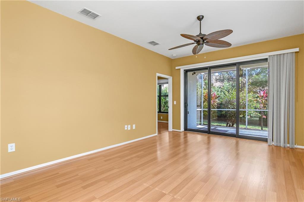 7820 Sandpine Court, Unit 2304 Naples, FL 34104 - Photo 6 of 50 a view of an empty room with wooden floor and a window