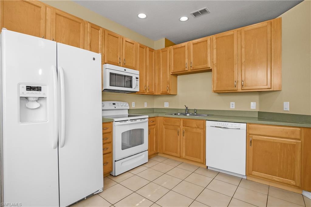 7820 Sandpine Court, Unit 2304 Naples, FL 34104 - Photo 8 of 50 a kitchen with granite countertop cabinets and steel stainless steel appliances