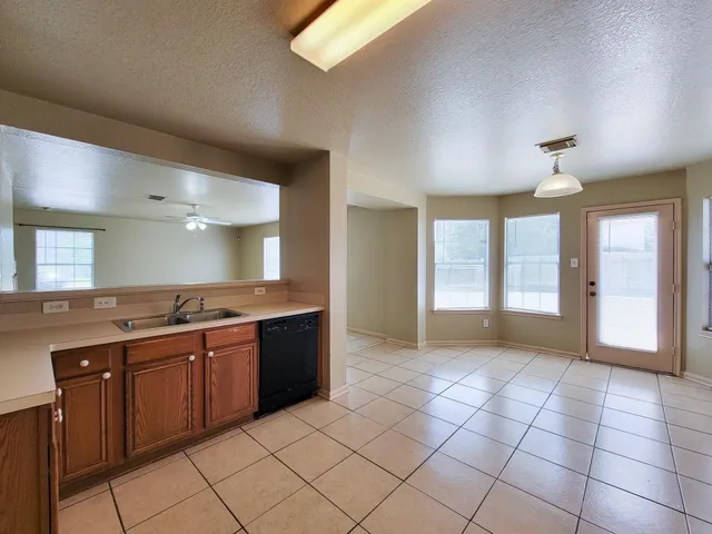a large kitchen with a stove a sink dishwasher and a refrigerator