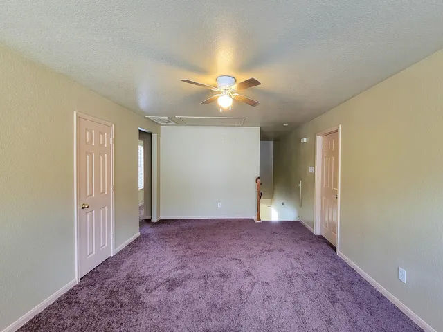 a view of an empty room with a ceiling fan