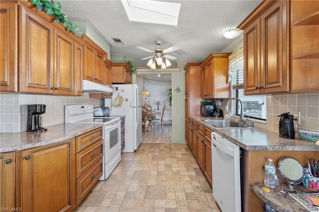 48 Oceans Boulevard, Unit 48 Naples, FL 34104 - Photo 11 of 26 a large kitchen with stainless steel appliances granite countertop a large stove a sink dishwasher and cabinets