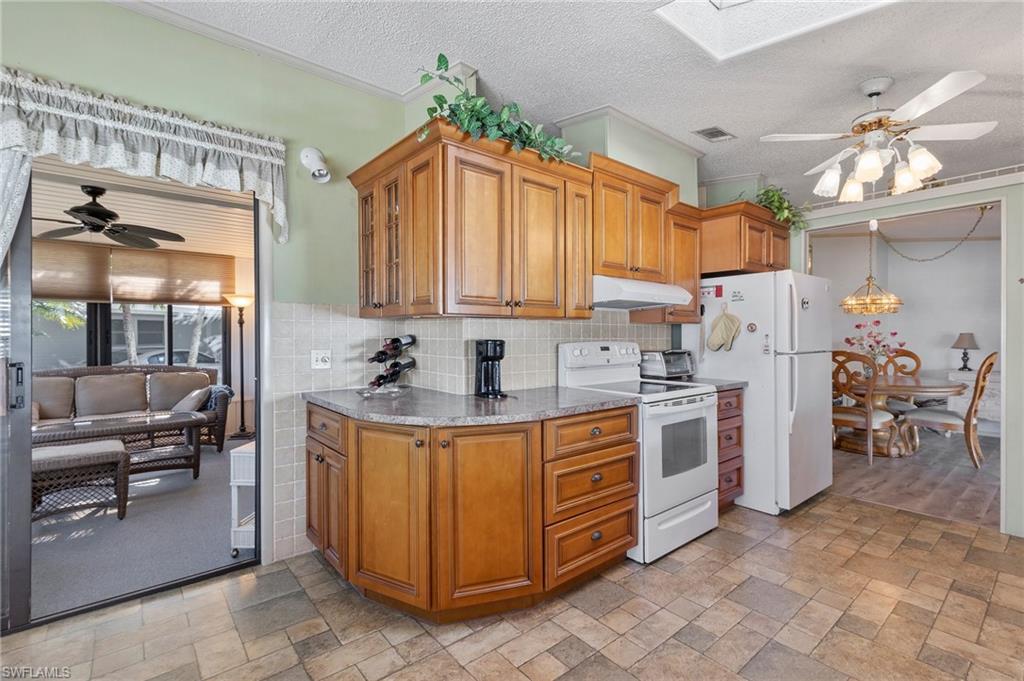 48 Oceans Boulevard, Unit 48 Naples, FL 34104 - Photo 12 of 26 a kitchen with a stove a refrigerator and a dining table