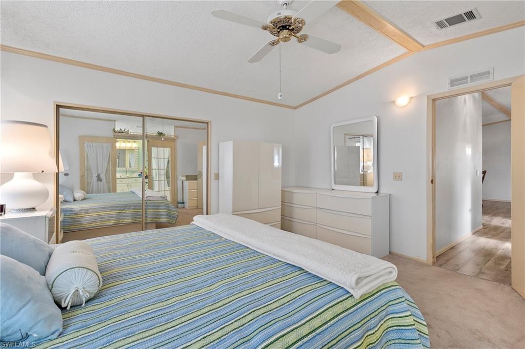 48 Oceans Boulevard, Unit 48 Naples, FL 34104 - Photo 15 of 26 a bedroom with a large bed and a chandelier